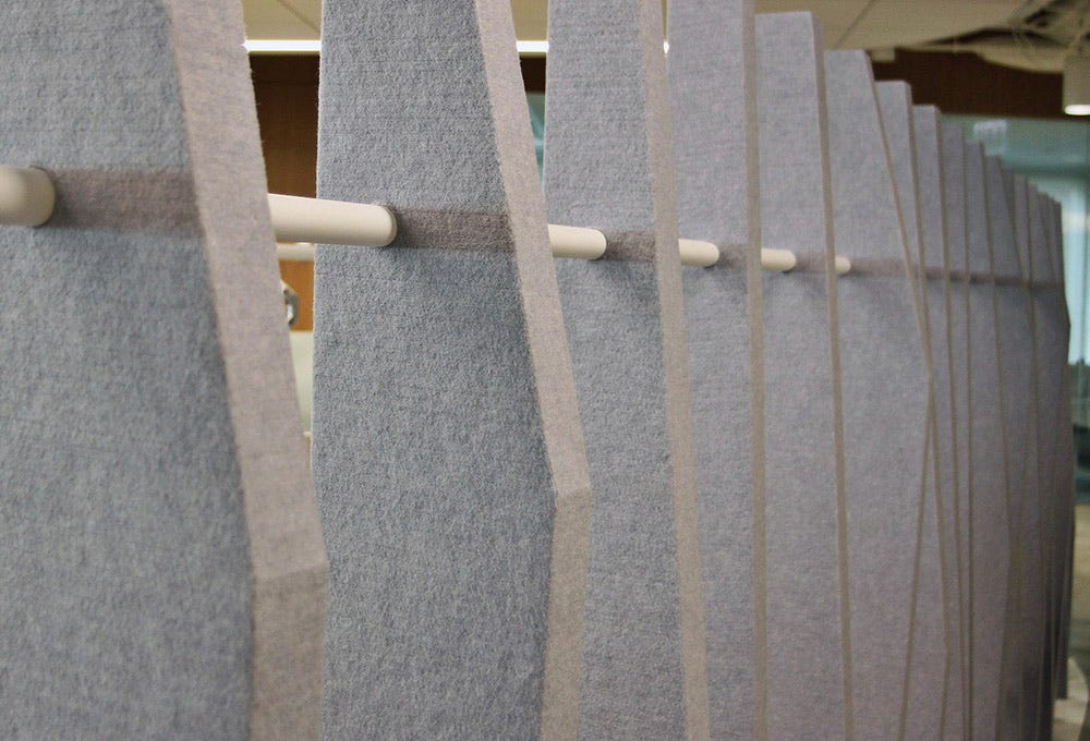 Custom acoustical felt partition design with metal feature